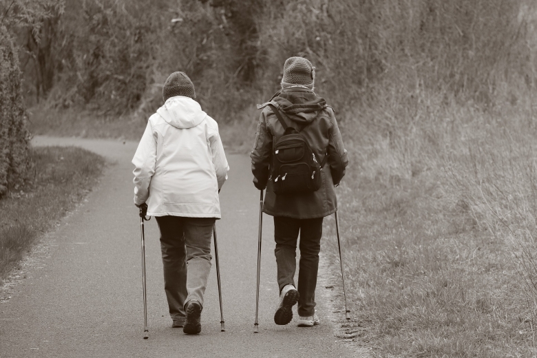 two seniors walking with poles